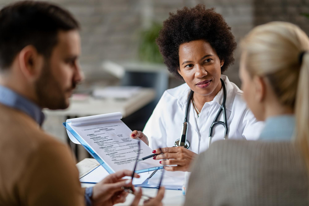 Médica apresentando propostas de convênios médicos para casal, destacando a importância da saúde e a escolha do plano ideal.